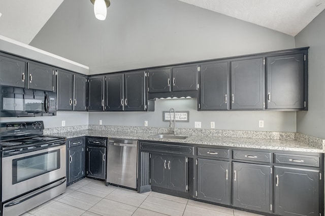 kitchen featuring a textured ceiling, stainless steel appliances, lofted ceiling, and a sink