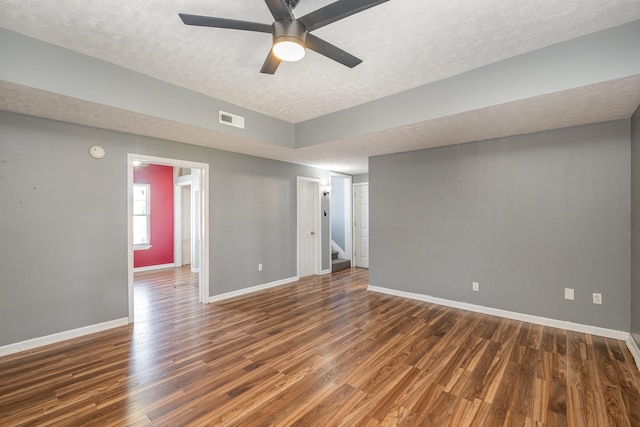 spare room with visible vents, baseboards, wood finished floors, a textured ceiling, and a ceiling fan