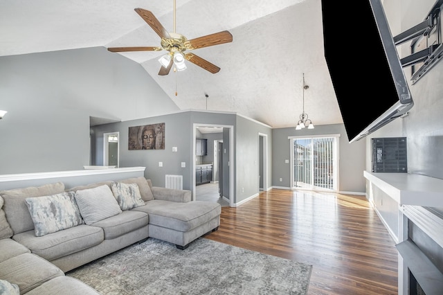 living area featuring visible vents, baseboards, wood finished floors, high vaulted ceiling, and a ceiling fan