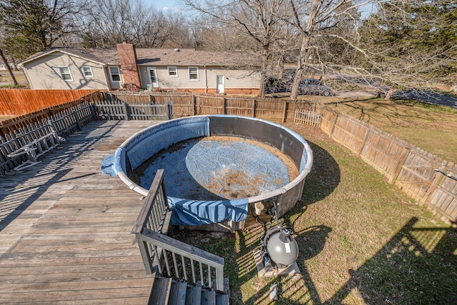 exterior space with a hot tub, a wooden deck, and a fenced backyard