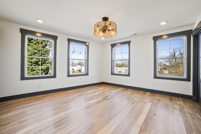 spare room featuring visible vents, baseboards, and light wood-style flooring