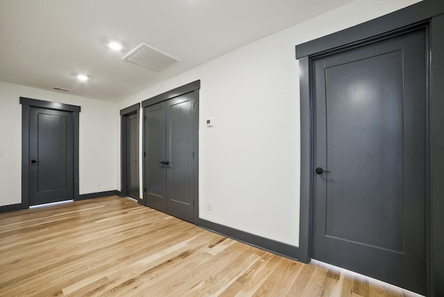 unfurnished bedroom featuring visible vents, light wood-type flooring, and baseboards