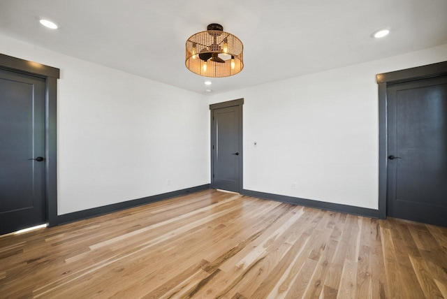 spare room with recessed lighting, baseboards, and light wood finished floors