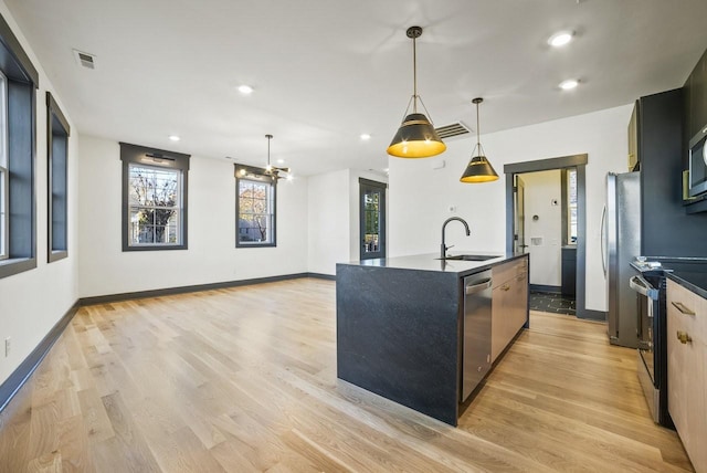 kitchen featuring a sink, stainless steel appliances, visible vents, and light wood-style flooring