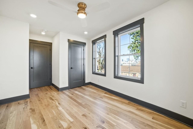 unfurnished bedroom featuring baseboards, light wood finished floors, recessed lighting, ceiling fan, and a closet