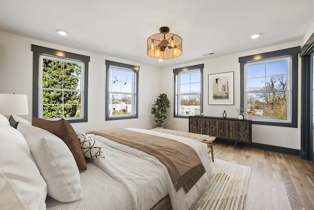 bedroom with visible vents, recessed lighting, light wood-type flooring, and baseboards