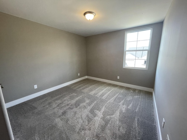 carpeted spare room featuring baseboards