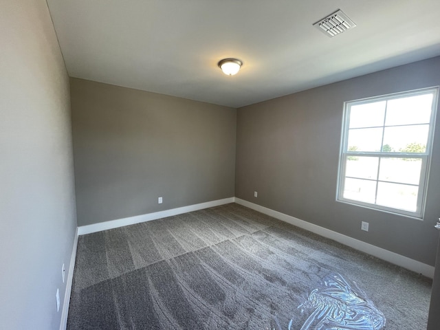 spare room featuring carpet flooring, baseboards, and visible vents