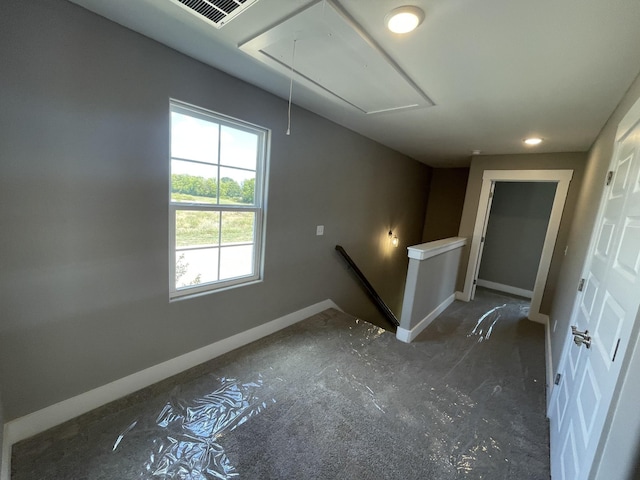 empty room with attic access, baseboards, and visible vents