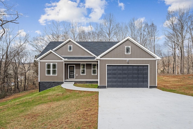 view of front of home with driveway, a porch, roof with shingles, an attached garage, and a front yard