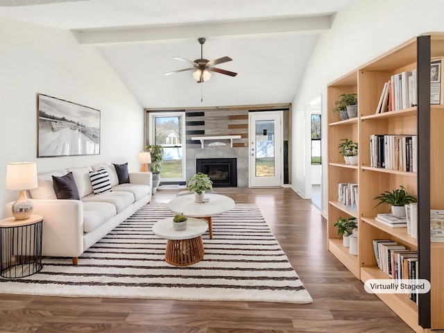 living room with ceiling fan, wood finished floors, vaulted ceiling with beams, and a tiled fireplace