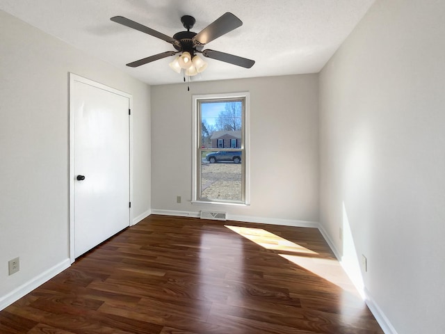 unfurnished bedroom featuring a ceiling fan, wood finished floors, visible vents, and baseboards