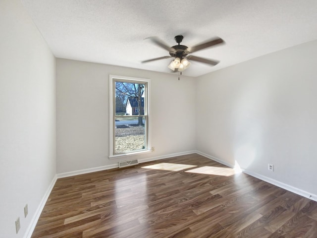 empty room featuring baseboards, wood finished floors, visible vents, and ceiling fan