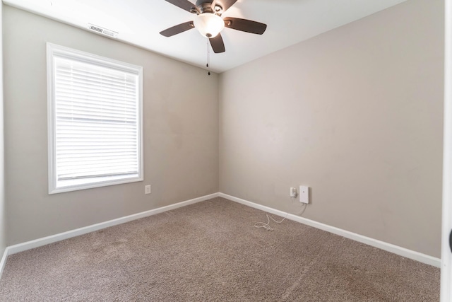 empty room with visible vents, carpet flooring, baseboards, and ceiling fan