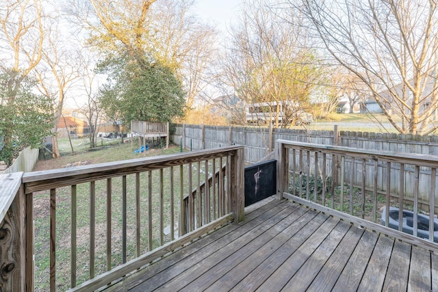 wooden terrace with a playground, a yard, and a fenced backyard