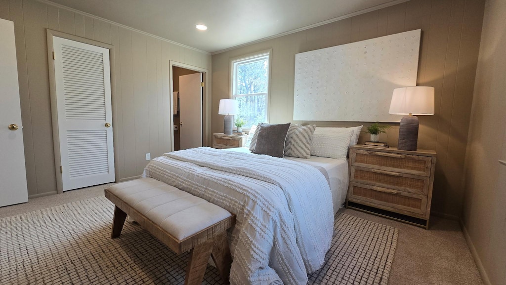 bedroom with crown molding, baseboards, and carpet floors