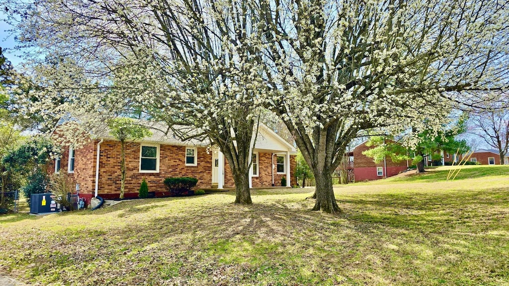 view of front of home featuring a front yard and brick siding