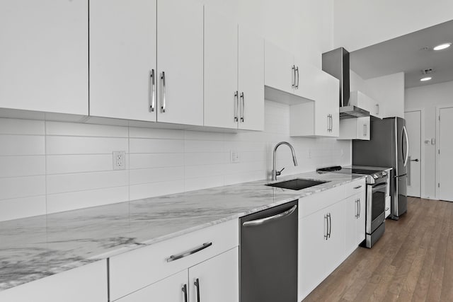 kitchen featuring tasteful backsplash, white cabinets, appliances with stainless steel finishes, and a sink