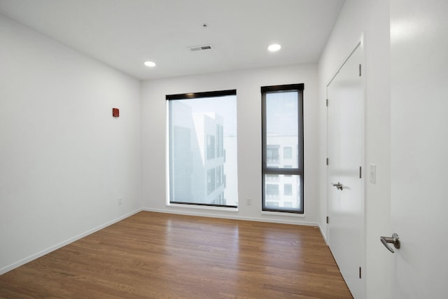 unfurnished room featuring visible vents, recessed lighting, baseboards, and wood finished floors