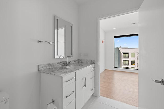 bathroom featuring tile patterned flooring, toilet, and vanity