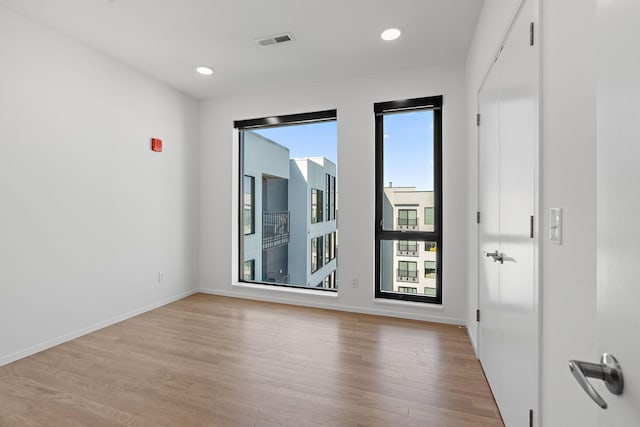 unfurnished room featuring recessed lighting, light wood-style floors, visible vents, and baseboards