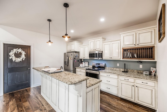 kitchen with dark wood-type flooring, light stone countertops, appliances with stainless steel finishes, and a center island