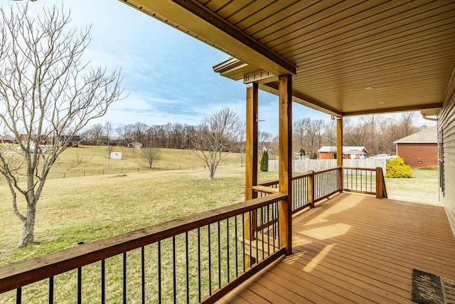 wooden deck featuring a lawn and fence