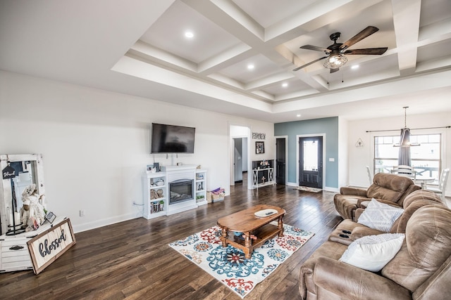 living area with dark wood-type flooring, baseboards, beamed ceiling, a glass covered fireplace, and coffered ceiling