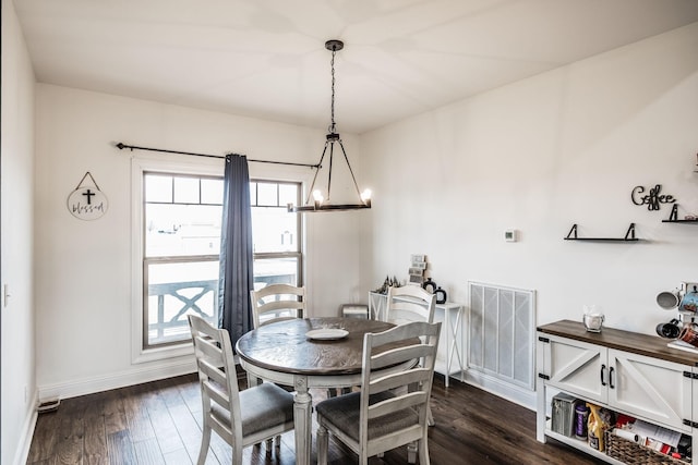 dining area with an inviting chandelier, baseboards, visible vents, and dark wood-style flooring