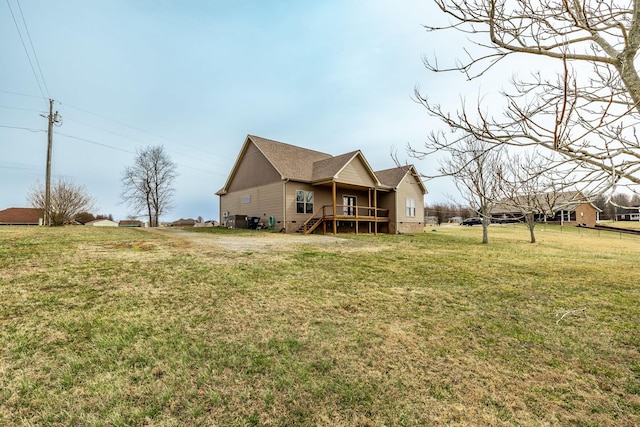 rear view of property featuring stairway, a wooden deck, and a yard