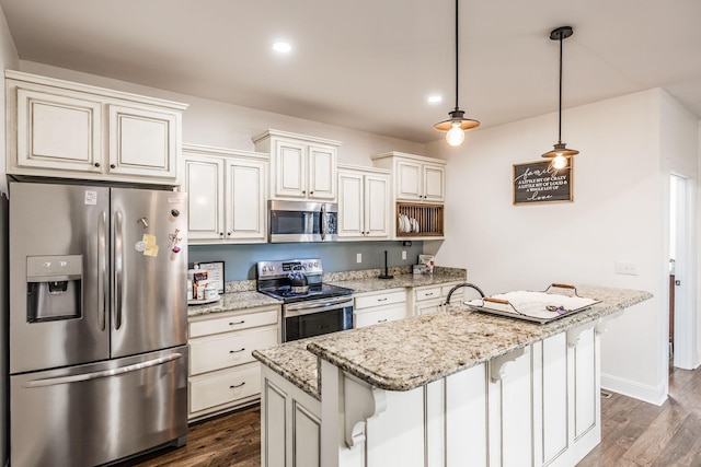 kitchen with light stone counters, stainless steel appliances, dark wood-type flooring, and a kitchen island with sink