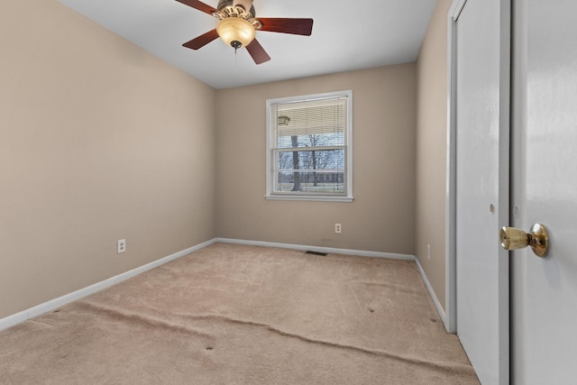 carpeted empty room featuring baseboards and ceiling fan