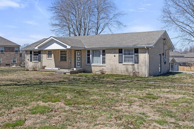 ranch-style house with brick siding, roof with shingles, and a front yard