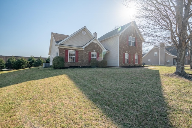 traditional-style home with a front lawn, brick siding, central AC, and a chimney