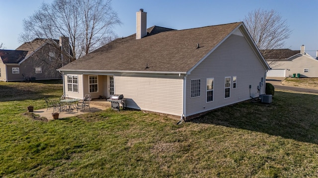 back of house with a patio, central AC unit, roof with shingles, a chimney, and a lawn