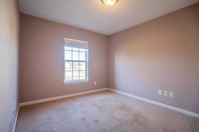 unfurnished room featuring baseboards and carpet