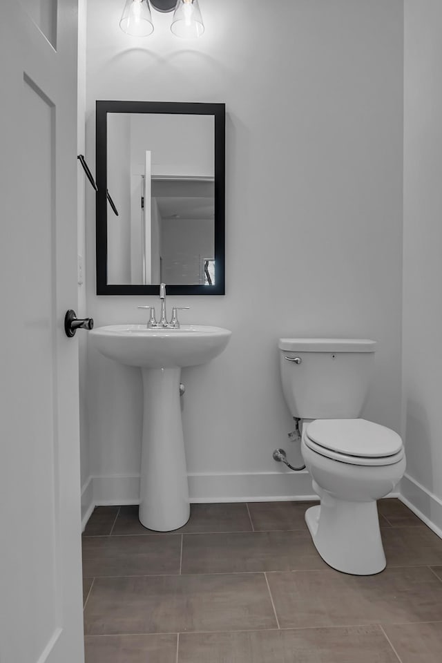 bathroom with toilet and baseboards