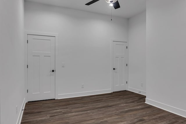 spare room with a ceiling fan, baseboards, and dark wood-style flooring