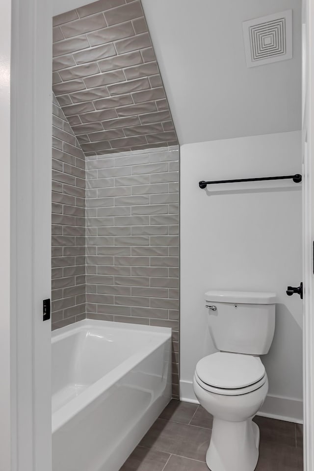 full bathroom featuring visible vents, baseboards, toilet, and vaulted ceiling