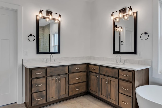 bathroom featuring double vanity, a freestanding tub, and a sink