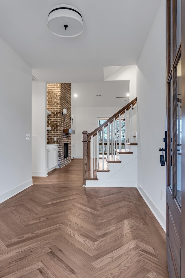 foyer with stairway, baseboards, and a fireplace