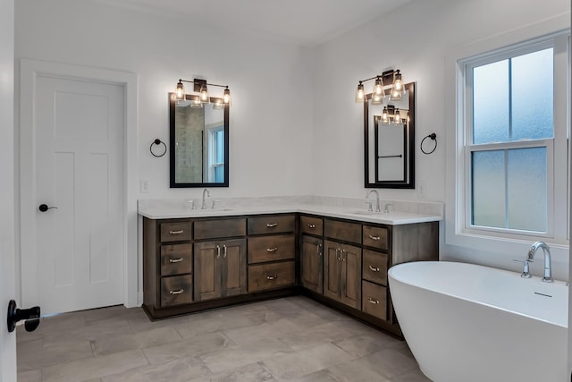 bathroom featuring double vanity, a soaking tub, and a sink