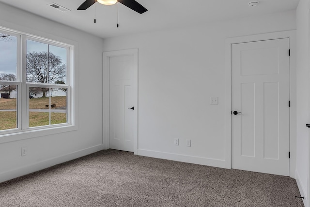 unfurnished room with a ceiling fan, baseboards, visible vents, and carpet floors