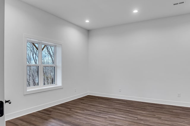 empty room with recessed lighting, visible vents, baseboards, and dark wood-style floors