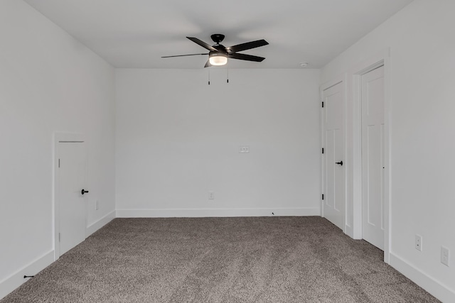 carpeted empty room featuring baseboards and ceiling fan