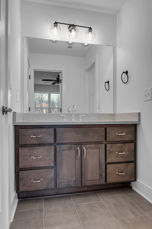 bathroom featuring tile patterned floors, baseboards, vanity, and a ceiling fan