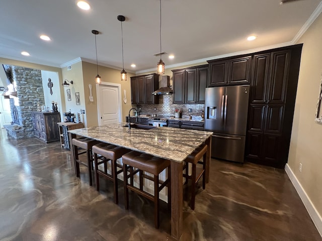 kitchen with a sink, stainless steel appliances, a kitchen breakfast bar, wall chimney exhaust hood, and backsplash