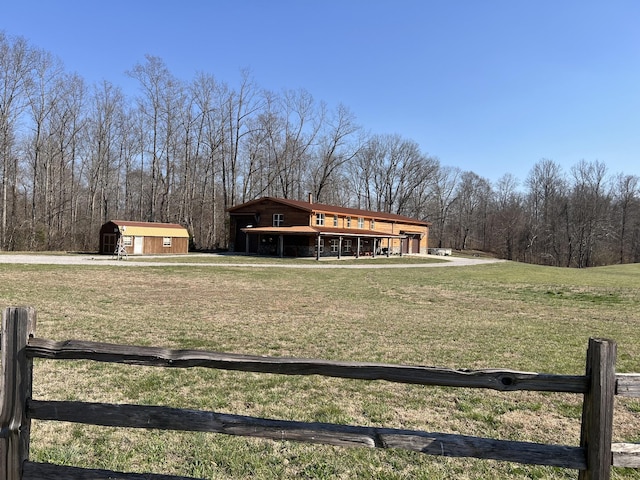 exterior space featuring a forest view, an outdoor structure, and a shed