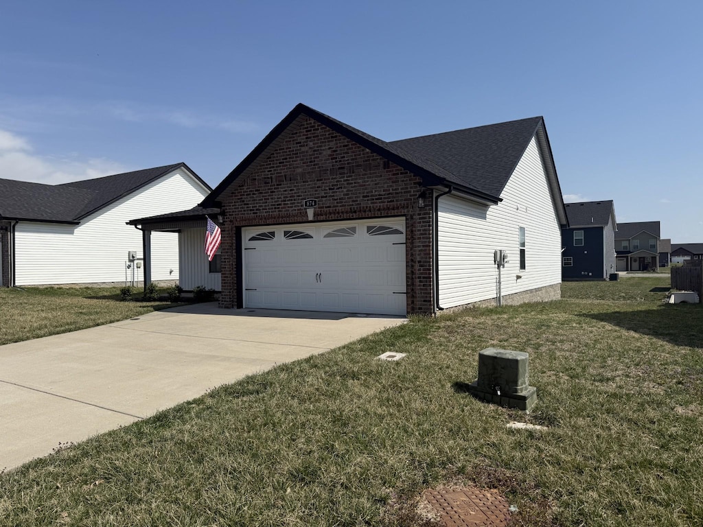 view of front of home featuring brick siding, an attached garage, concrete driveway, and a front yard