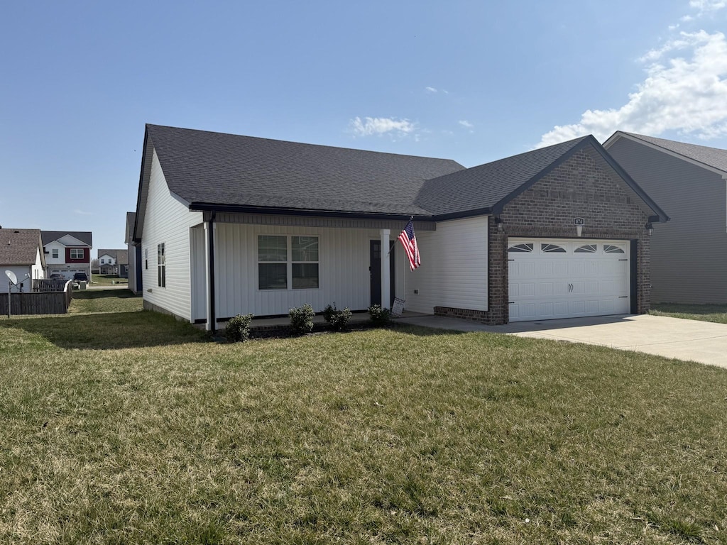 view of front of home with a front yard, an attached garage, brick siding, and driveway